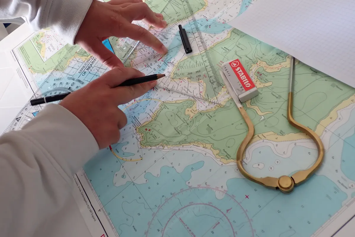 Calcolo della rotta nautica: squadrette e compasso a punte sulla carta nautica, per misurare direzione e distanza