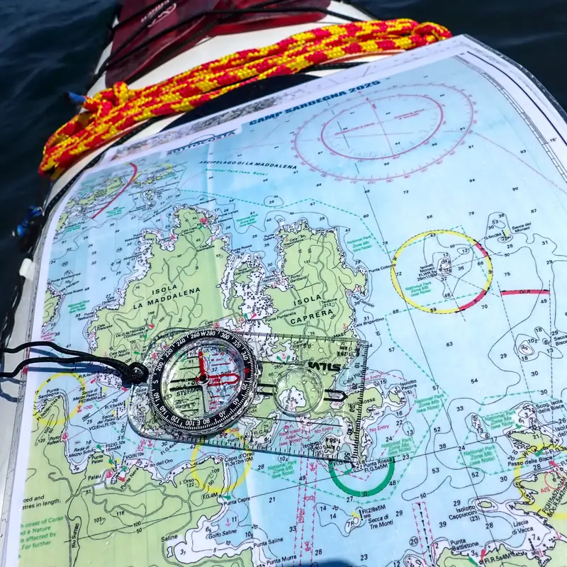 Formazione e certificazioni di kayak da mare: carta nautica con la bussola sul ponte del kayak