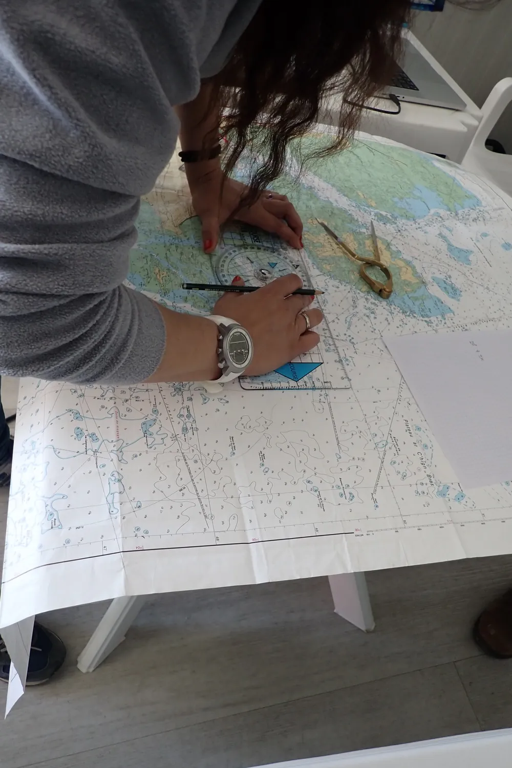 Corso istruttori kayak da mare: carteggio in aula, con matita e compasso sulla carta nautica