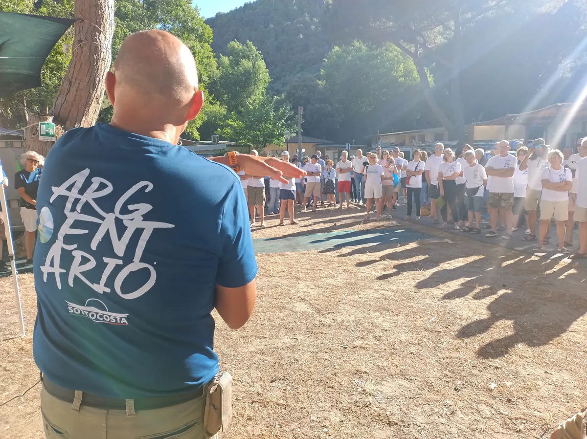 Decalogo del kayak da mare, dalla regola alla pratica: briefing a un raduno, con i partecipanti davanti a chi parla
