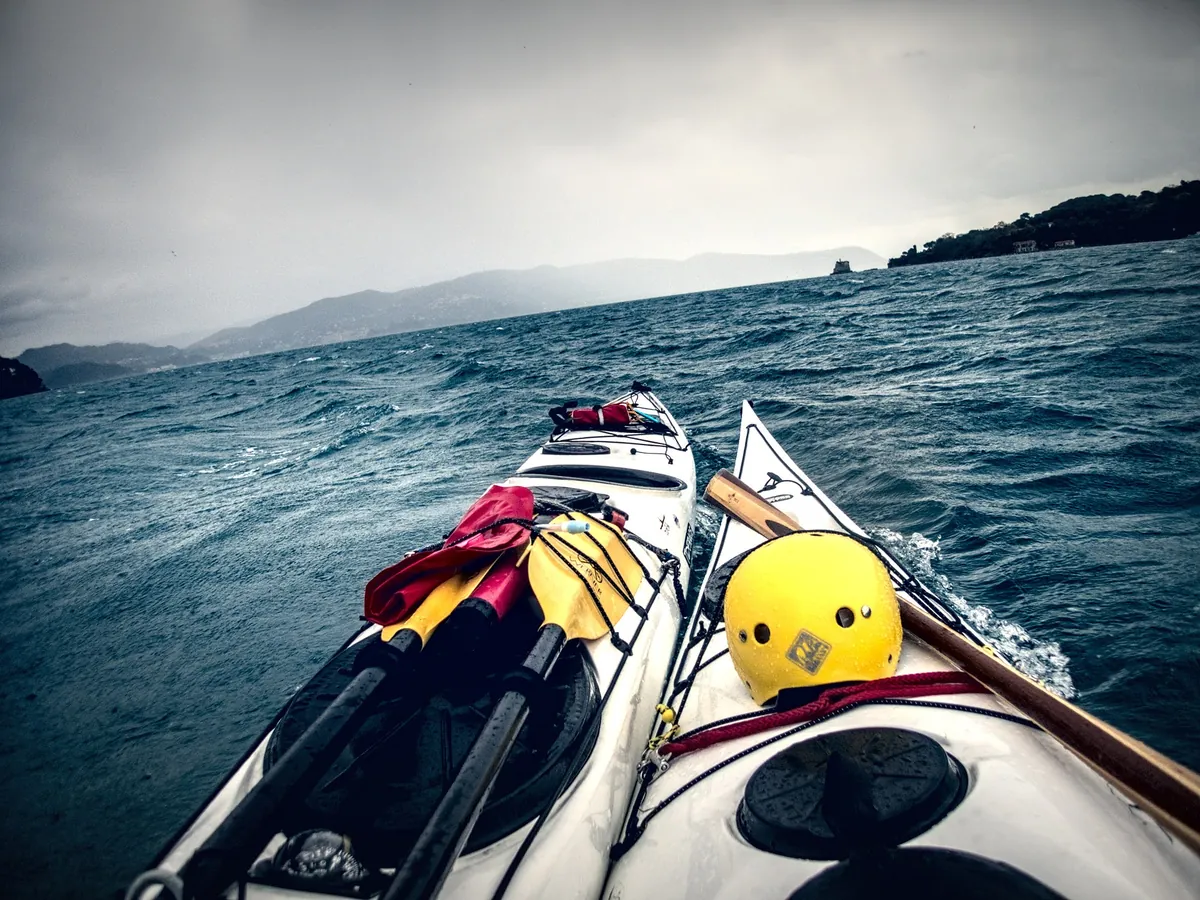 Decalogo del kayak da mare, la sicurezza: due kayak affiancati sul mare mosso, con casco, pagaie e lifeline in coperta