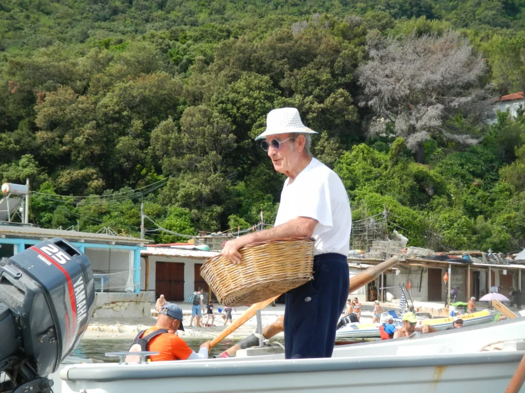 Di ritorno da Conero in kayak 2018: pescatore che porta un cesto sulla barca
