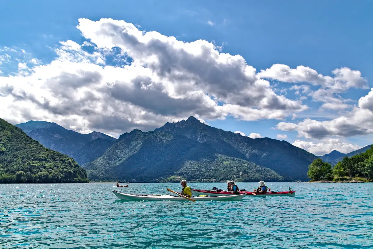 Formazione e certificazioni di kayak da mare: gruppo di kayak in navigazione sul lago tra le montagne
