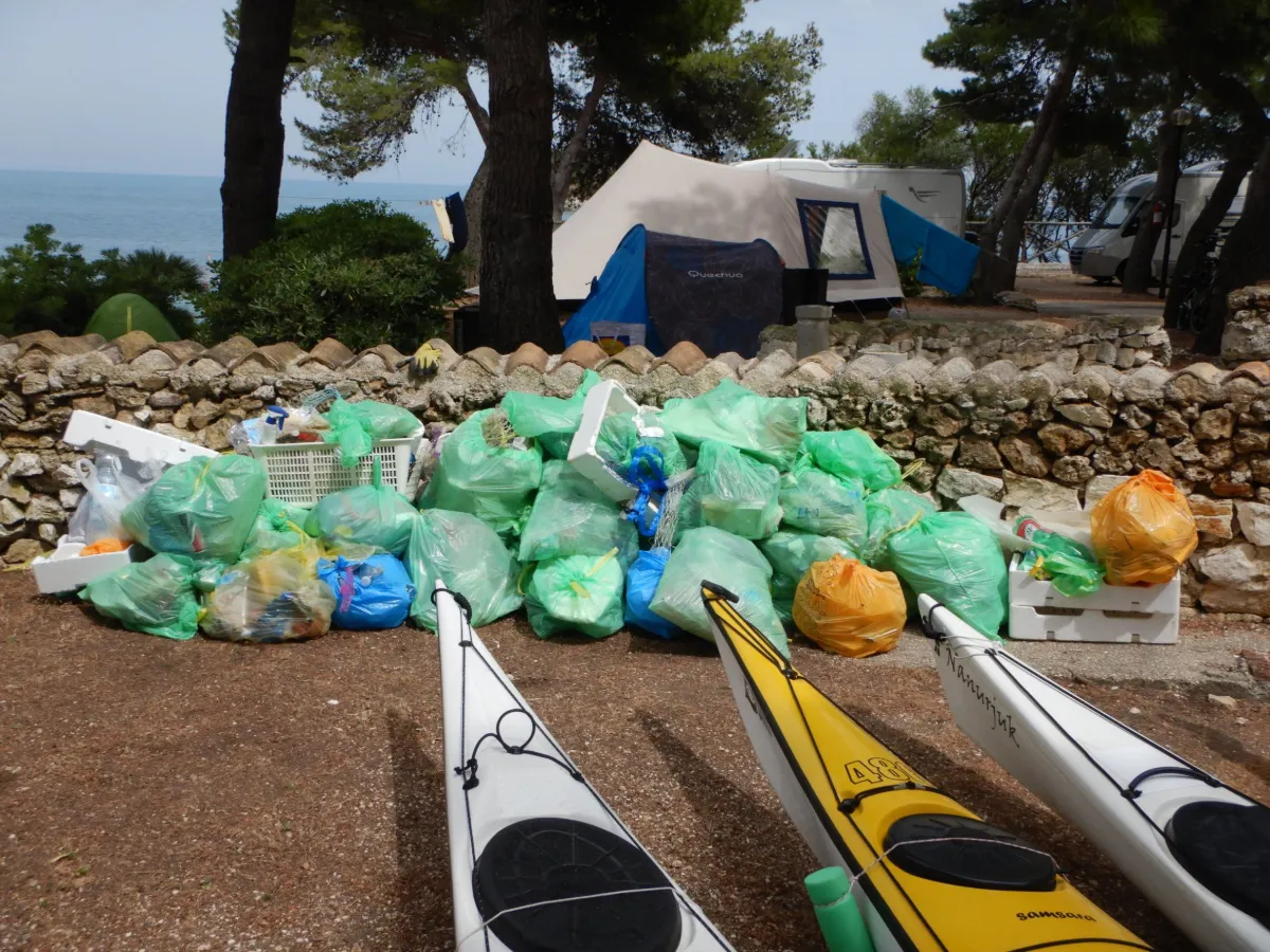 Sottocosta e il rispetto per il mare: i sacchi di rifiuti raccolti sulla spiaggia al Kayak Camp del 2019, accanto ai kayak da mare