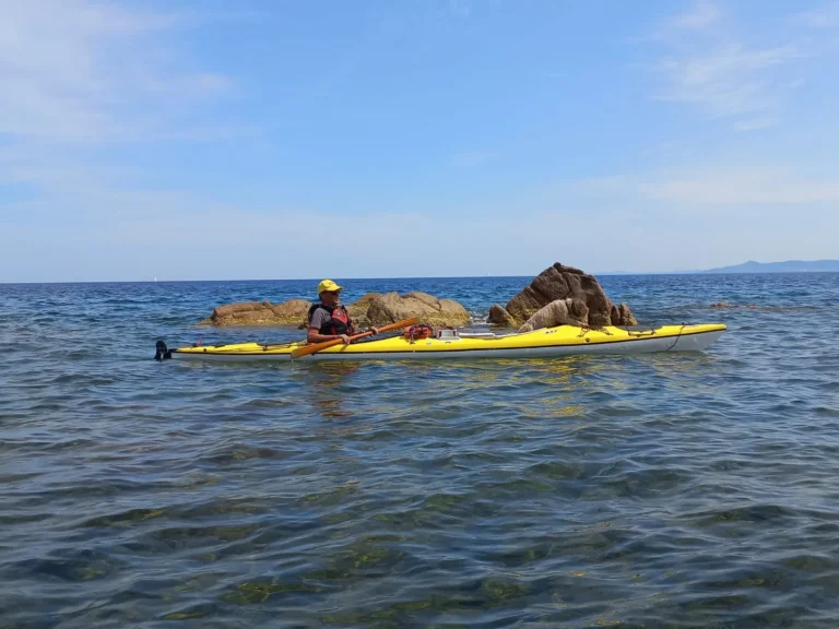 Sottocosta Camp 2022 a Calacavallo (Sardegna): kayak giallo in navigazione accanto allo scoglio