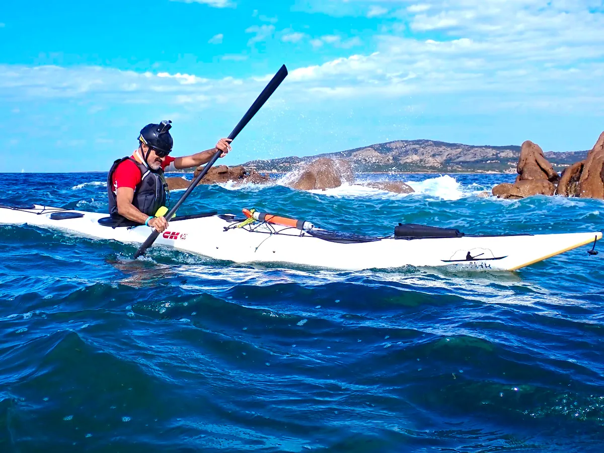 Tecnica del kayak da mare: pagaiatore sul mare mosso che ruota il busto, con la pala alta