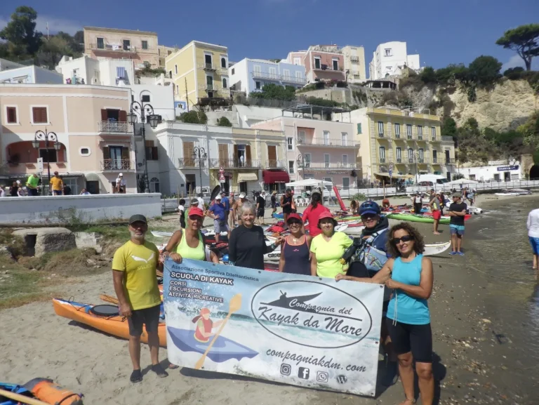 News XXI Edizione Pontine Maremarathon 2023: partecipanti con lo striscione sulla spiaggia del porto